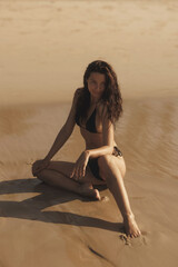 Summer is the perfect time to be sexy. Fashion shot of a gorgeous young woman in black bikini on the beach. Femininity and female beauty high quality photo