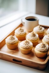 Cupcakes with vanilla frosting and a cup of coffee, candid bakery setting photography
