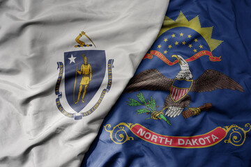 big waving colorful national flag of north dakota state and flag of massachusetts state .