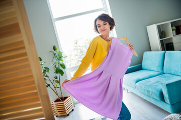 Photo of lovely pretty lady choose new dress in modern store boutique trying showroom