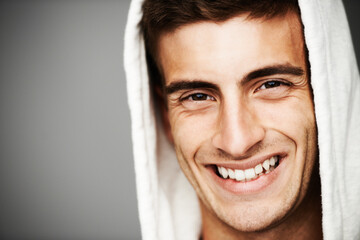 Portrait, smile and man in hoodie for fashion isolated on a gray studio background mockup space....