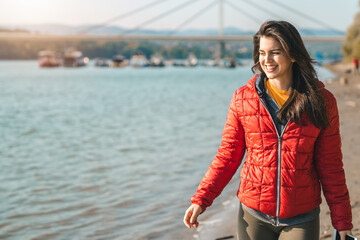 Attractive athletic woman wearing casual clothes and smiling while walking outdoors.