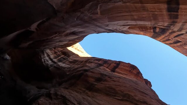 Stunning POV view inside deep Glen Canyon rock walls and clear blue sky