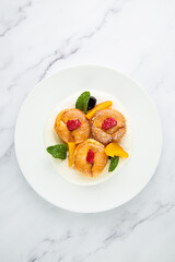 muffins with peach, raspberry, black berry and mint covered with powdered sugar, side view