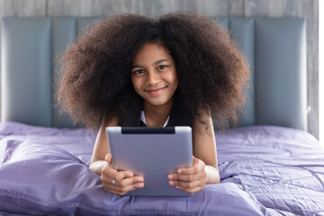African black child girl afro hair cute lovely lay on bed with tablet computer happy self learning...