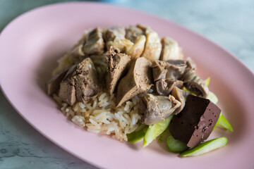 Rice steamed with chicken soup and offal with cucumber, sale at Thai street food market or restaurant in Thailand