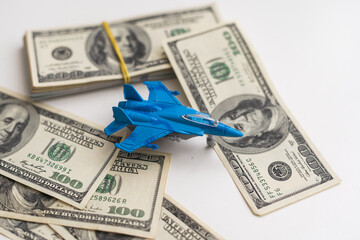 Military toy airplane jet aircraft and dollars - fighter isolated on white background