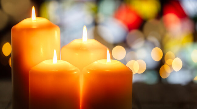 Candles in a church with stained glass window background
