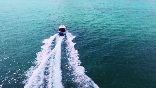 Aerial drone shot of speed boat fast movement on aqua sea.