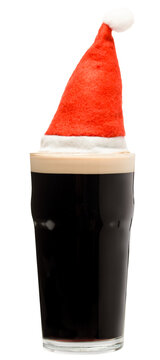 Pint glass of dark beer or stout ale with red christmas or santa claus hat isolated