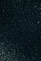 Shining sparkling black blurred background for holiday design. Christmas abstract sparkles, selective focus