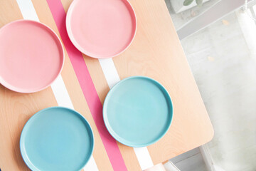 Colourful empty plates on a wooden table at a coffee shop.
