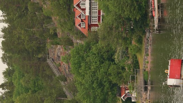 Red Scandic Wooden Houses On Island Coast In Summer Cloudy Day. Nordic Architecture. Vertical Footage Video Hyperlapse. Scandinavian Culture And Nature. Travel Concept To Sweden.