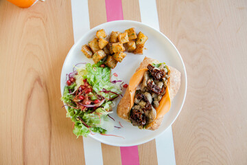 Chicken open faced sandwich in ciabatta bread served with veggies on the side.