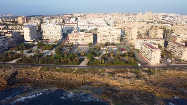 Drone dolly shot of Cabo Cervera cliffs and buildings in the background during a golden hour morning between Torrevieja and La Mata, Costa Blanca, Spain