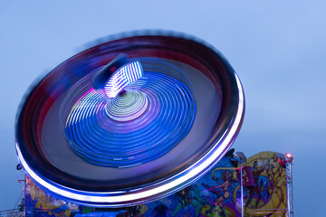 Long exposure shot of Carrousel with colourful light at Torrevieja fun fair during blue hour