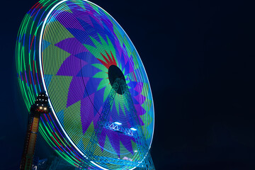 Ferris wheel with bright lights of different colours at the fun fair in Torrevieja. Long exposure...