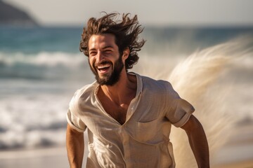 n image of a young, handsome man, embracing the liberating feeling of joy as he runs along the beach, the wind tousling his hair - obrazy, fototapety, plakaty
