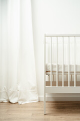 White wooden baby crib in nursery room