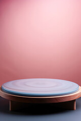 Pink product display podium for natural product. Circular shape base on a wooden stand.