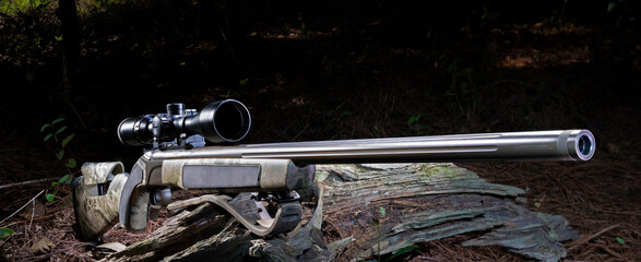 Break action modern blackpowder rifle ready to shoot in a dark forest.