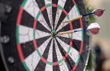 Two darts sticking out of wooden target closeup. Sports entertainment in resort concept