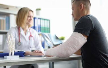 Man with broken arm at doctor appointment in clinic. Medical treatment of intra-articular fractures concept