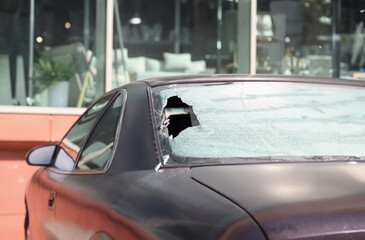 Closeup of broken rear glass of black car. Car insurance concept