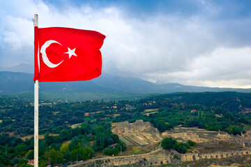 Waving flag of Turkey and aerial view of ancient ruins of antique architecture of Tlos. Mugla Province, Turkey