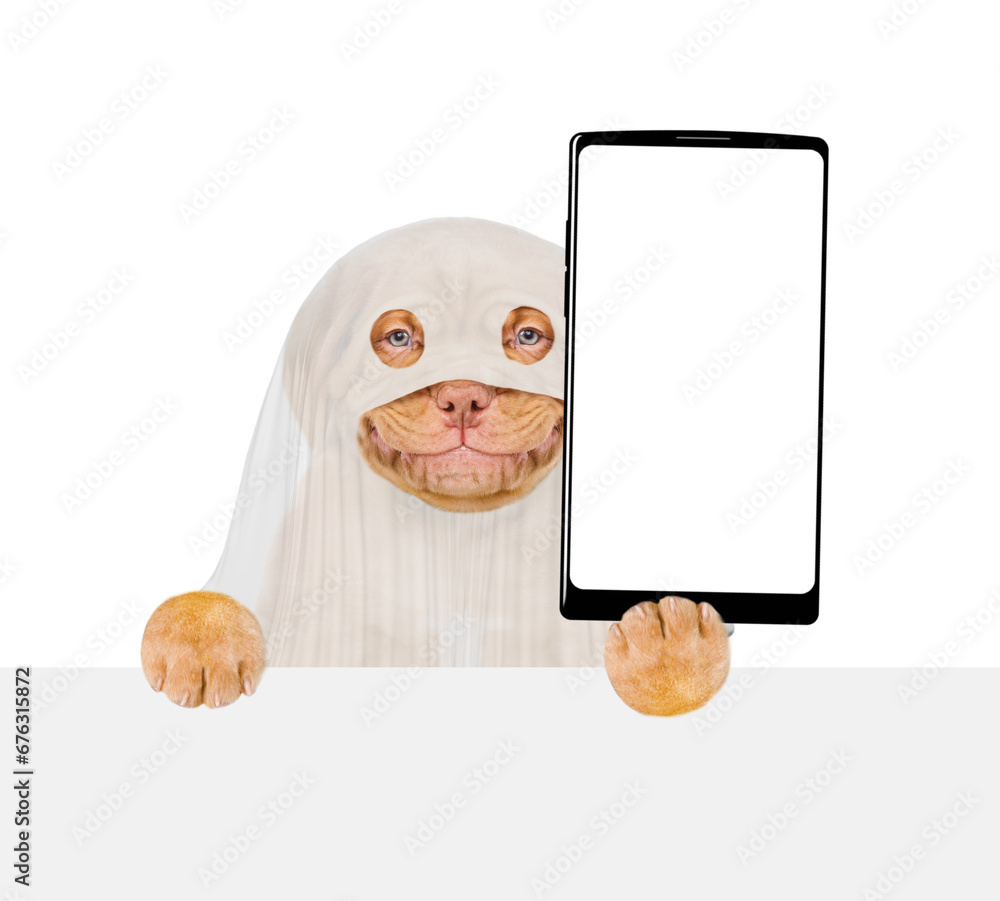 Poster smiling mastiff puppy celebrating halloween in ghost costume, showing big smartphone with white blan