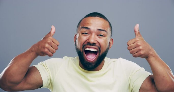 Happy man, thumbs up and celebration for success, winning and excited for like emoji and vote in studio. Wow face of african person or winner with yes hands, bonus and good news on a gray background