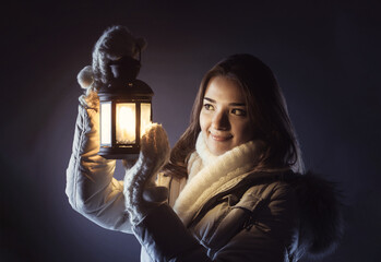 beautiful girl on winter snow with christmas lantern