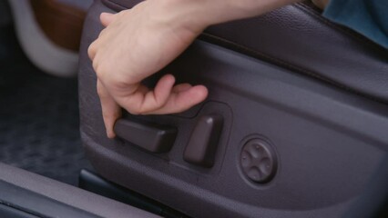 Closeup stab shot of hand of unrecognizable driver adjusting drivers seat in car using mechanical seat adjusments