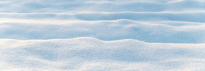 Winter background with snow-covered wavy uneven ground surface, snow texture