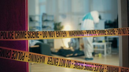 A crime laboratory worker is taking pictures of marked pieces of evidence and blood splashes