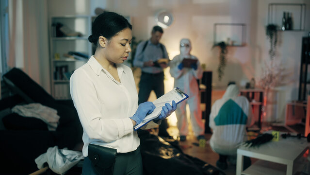 A woman detective is documenting evidence at the crime scene as part of a crime investigation