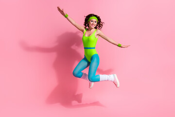 Photo of carefree sportive trainer lady jumping high practice cardio routine isolated on pastel...