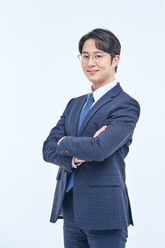 A young and handsome Asian man in a suit is wearing glasses and making various facial expressions and hand gestures.