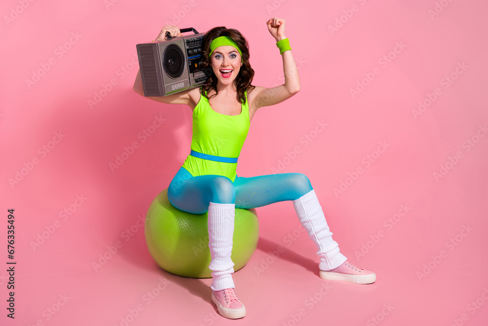 Sticker Photo of excited sporty lady trainer celebrate opening new sport club sit fitball with boom box isolated pastel color background