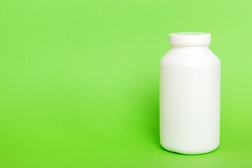 supplement pills with medicine bottle health care and medical top view. Vitamin tablets. Top view mockup bottle for pills and vitamins with green leaves, natural organic bio supplement, copy space