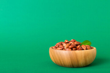 Fresh healthy peanuts in bowl on colored table background. Top view Healthy eating bertholletia concept. Super foods