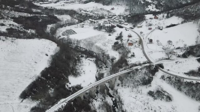 Footage of a snow covered countryside in mountion from above