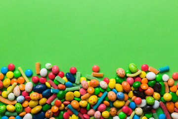 Mixed collection of colorful candy, on colored background. Flat lay, top view. frame of colorful chocolate coated candy