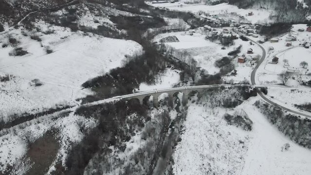 Footage of a snow covered countryside in mountion from above