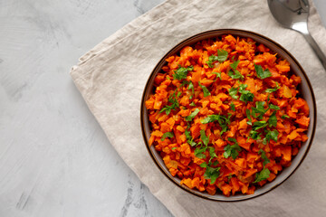Homemade Smoky Spiced Carrot Rice with Parsley in a Bowl, top view. Flat lay, overhead, from above.
