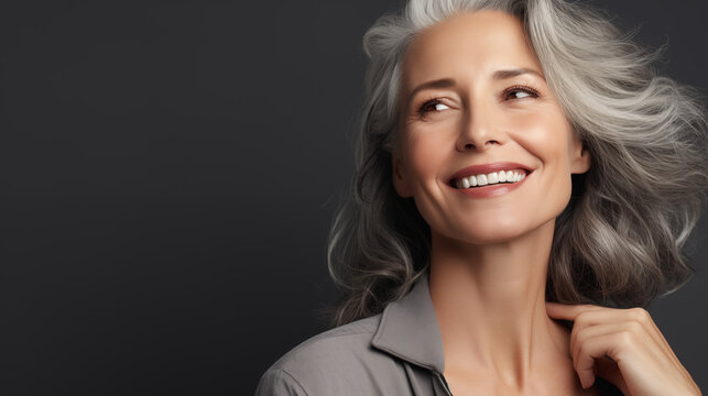 Beautiful aging young looking and smiling woman. Advertising concept for cosmetics and beauty products. Gray hair and healthy skin.