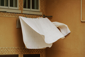 White sheets drying on a line on a windy day.
