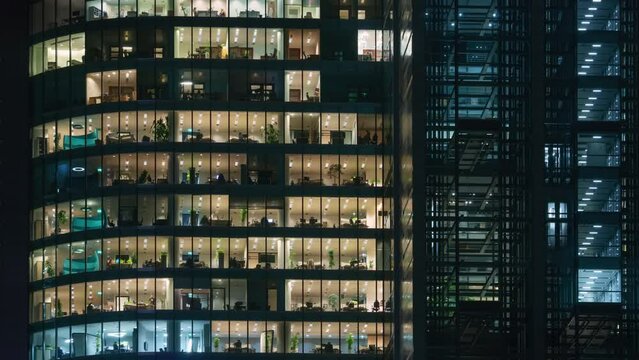 Time lapse office windows lights in business center building facade, people working late night. Corporate business, high skyscraper glass surface. Light in building windows turn on and off in evening