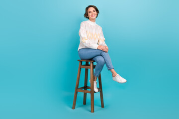 Full body cadre of cheerful attractive girl sitting wooden comfortable chair pub relaxation atmosphere isolated on blue color background