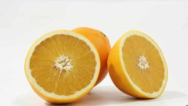 Ripe oranges rotate on a white background. Oranges close-up on white.